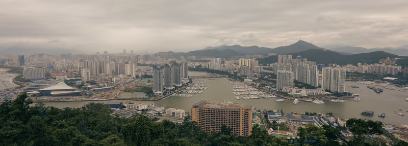 灰蒙天空下的城市天际线与游艇码头